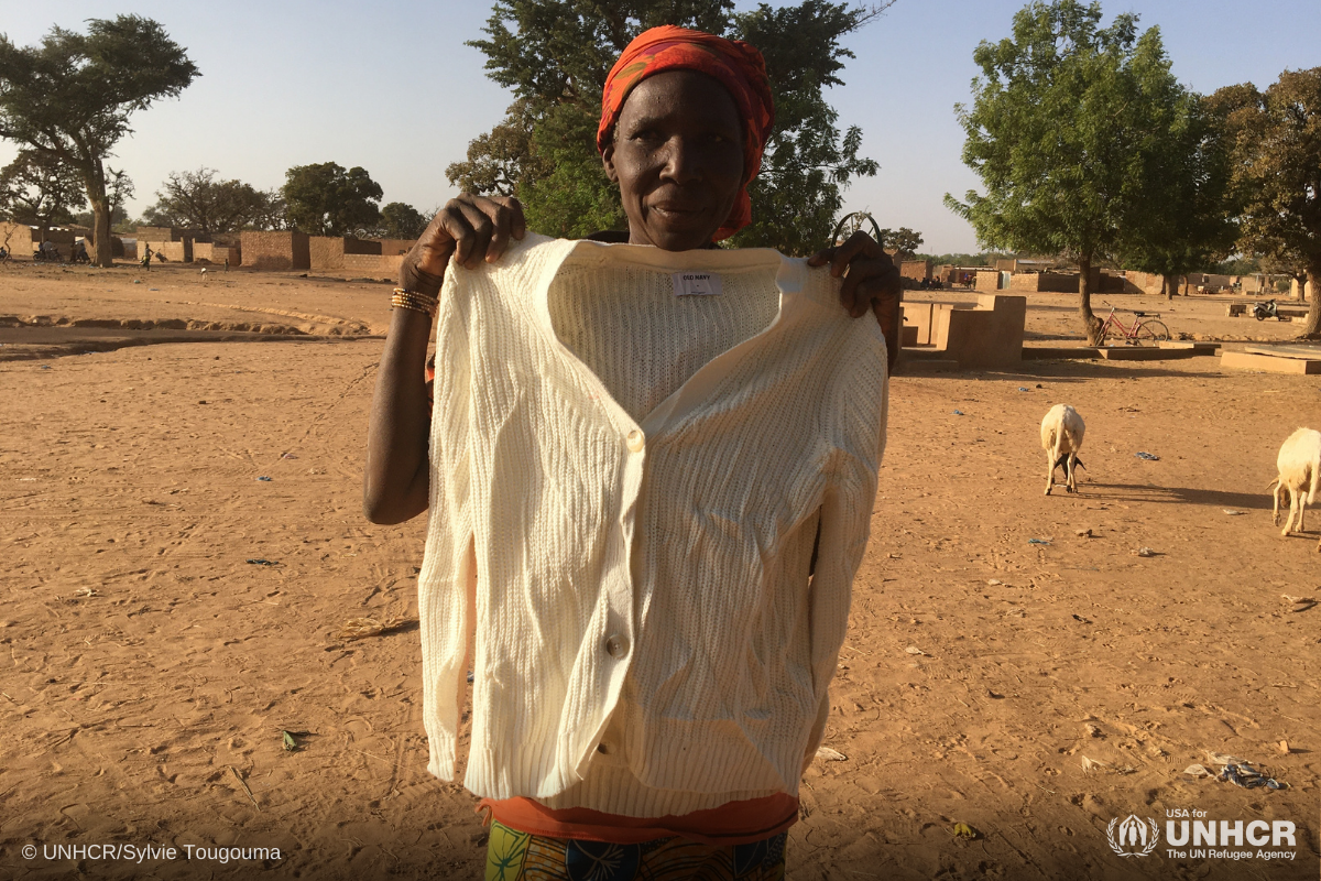 Zonabo, a refugee woman from Burkina Faso, receives a shirt from Gap in-kind donation
