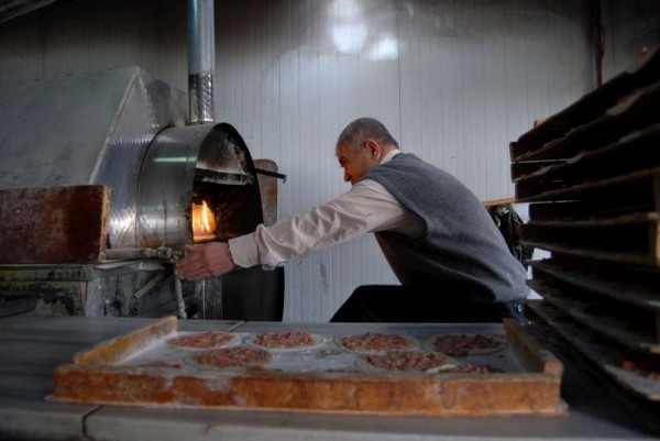 Abu Mahmood, 48, makes pizza at his bakery in Jordan's Za'atari refugee camp. © UNHCR/C.Dunmore