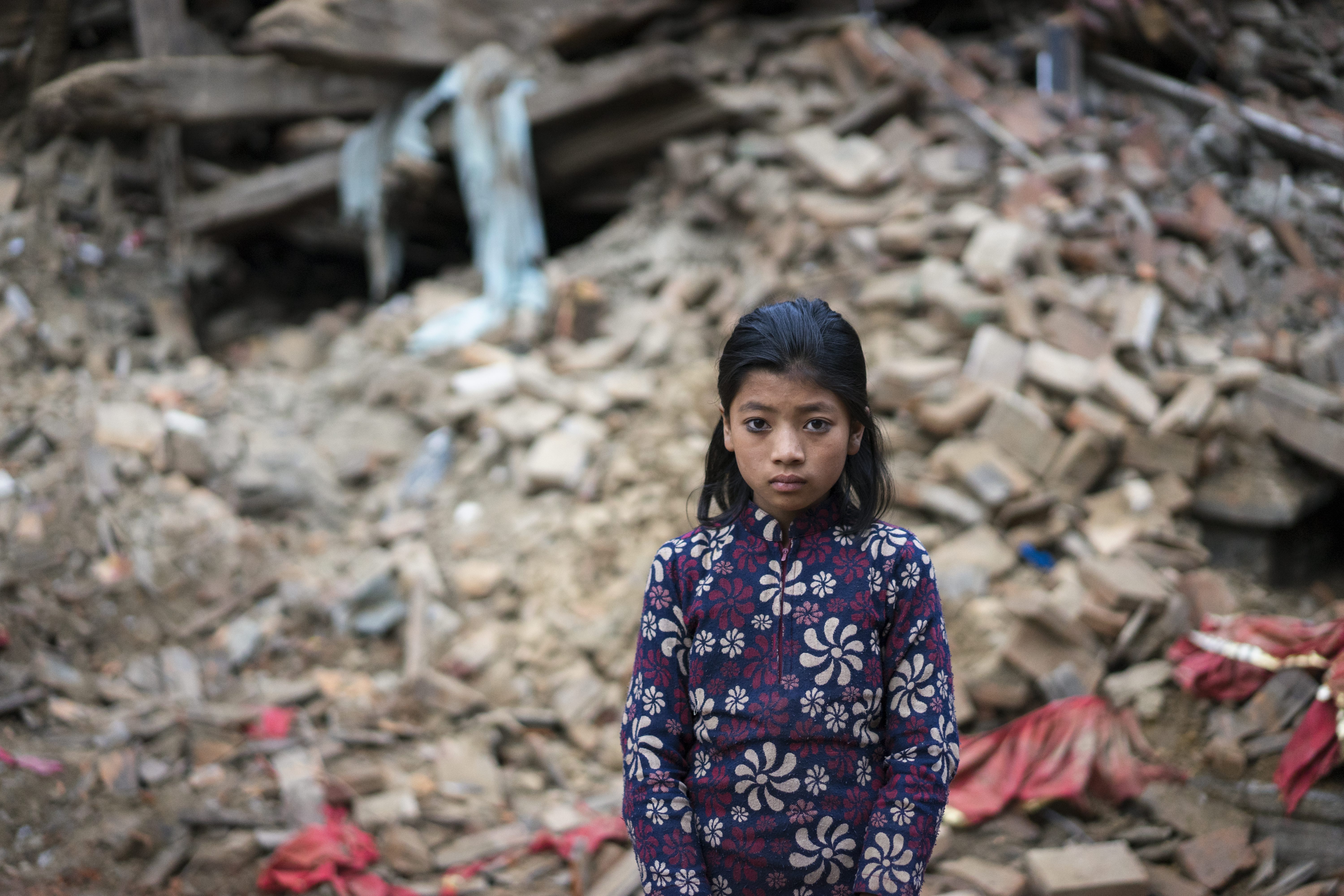 12-year-old Nanu Tatya standing in front of a rubble in Bhaktapur in the outskirts of Kathmandu.  Nanu is still scared from the earthquake. She was too afraid to speak about the massive quake and the aftershocks. Her relatives said her house had been destroyed and she was living in a plastic tent with her family. / UNHCR / Brian Sokol / 29 April 2015