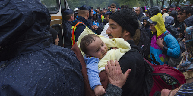 Hungary. Refugees with a sck baby being bused out of a collection point near the Serbian border, to be taken for registration.