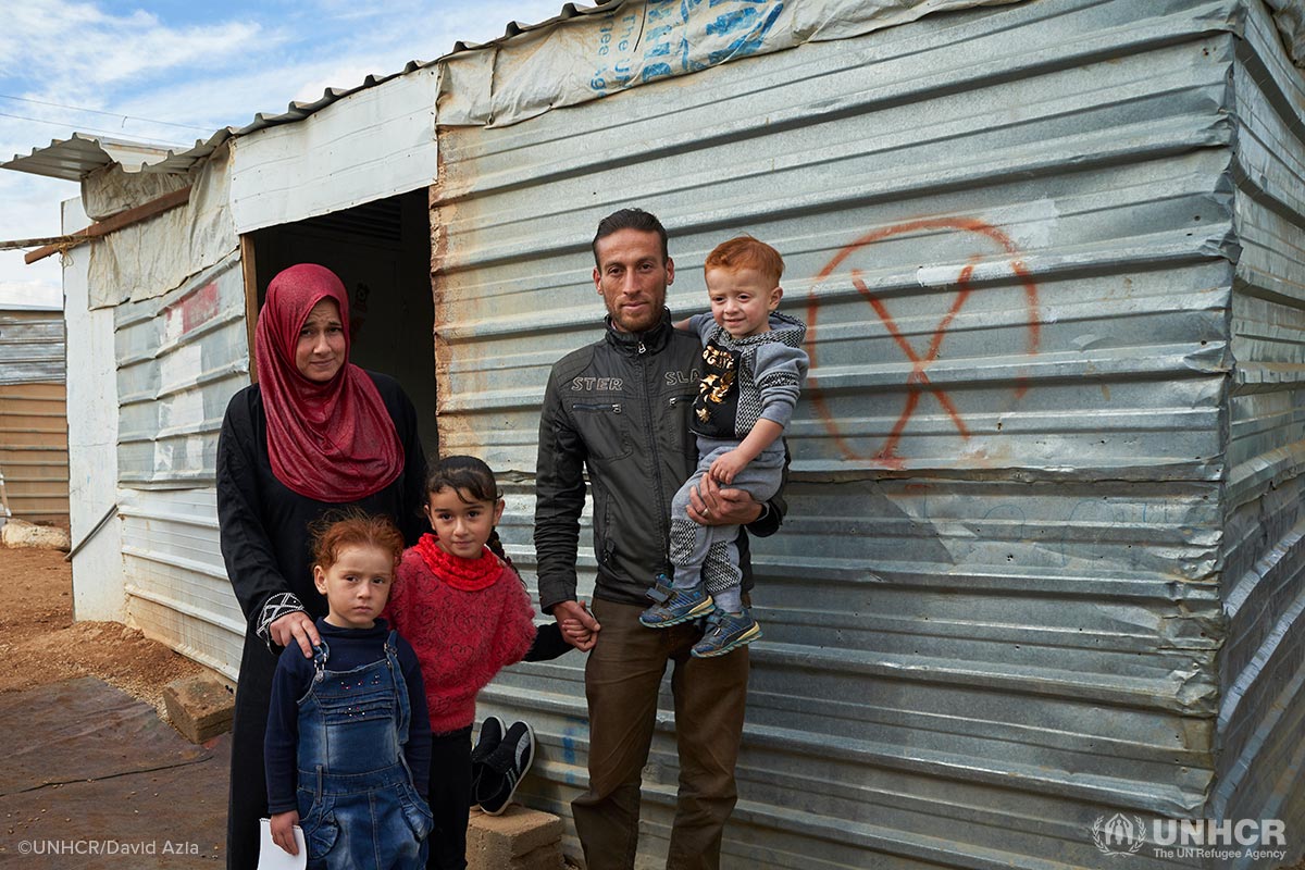 From left, Syrian refugee Aysha, 28, daughters Arwa, 5, Fatmeh, 7, husband Ghareeb, 32, and son Emad, 2.5, outside their shelter at Zaatari refugee camp, Mafraq Governorate, Jordan. Aysha and her family had yet to receive winter cash assistance and were in dire need of help.