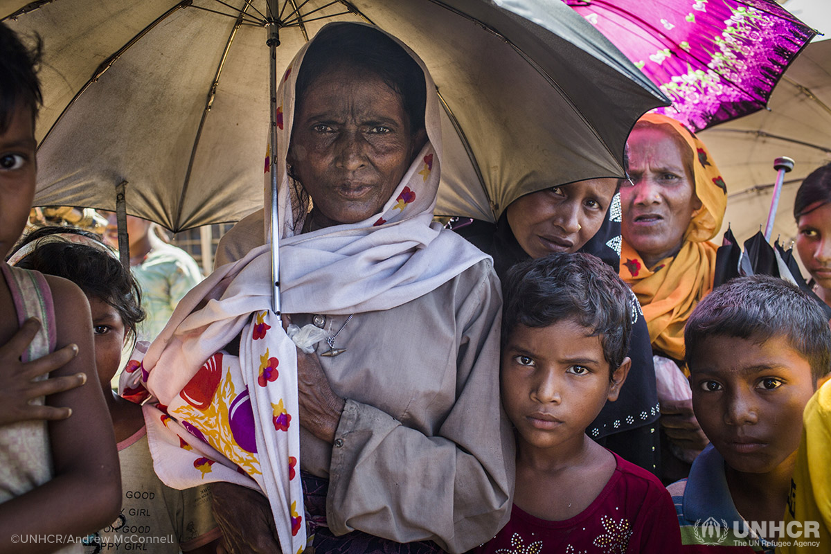 Marjan, 60, and her granddaughter Jannat Ara, 7, (in red) stand among other Rohingya refugees to receive aid at Kutupalong camp in Bangladesh. They fled their home in Myanmar two months ago with four other family members.