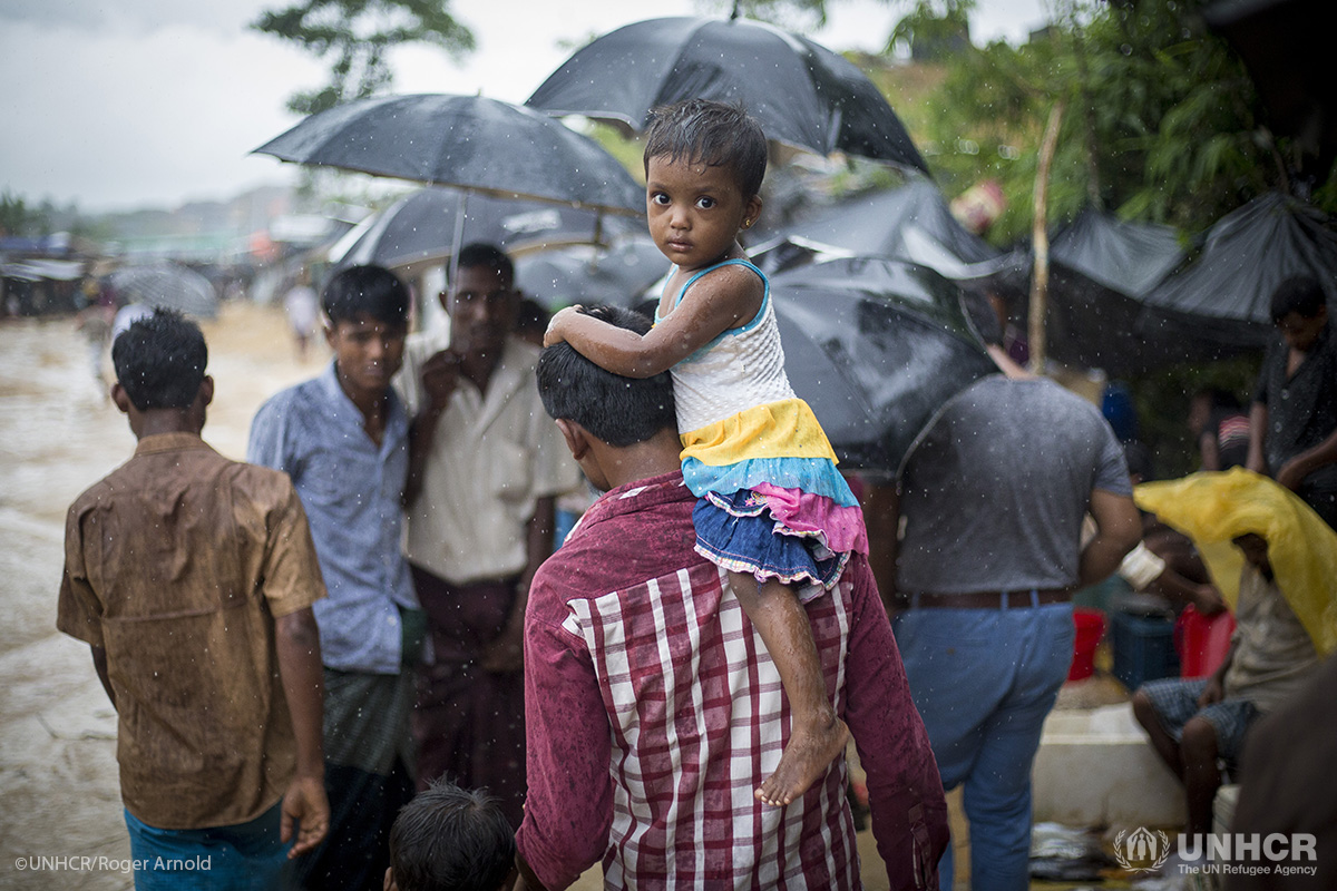 Rohingya refugees make their way down a footpath during a heavy monsoon downpour in Kutupalong refugee settlement.