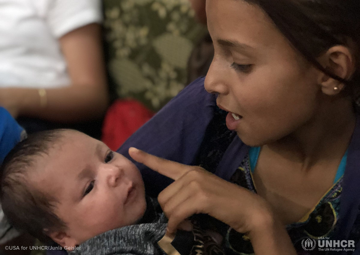 12-year-old Jihan holds her baby brother, Yahya.