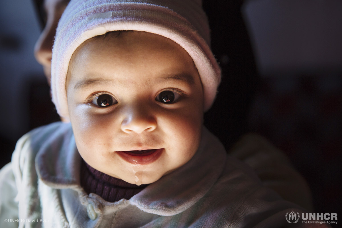 Syrian refugee Mona, 6 months, is held by her aunt Samira, 38, in the apartment they share with their family in a substandard building in the Bekaa Valley, Lebanon.