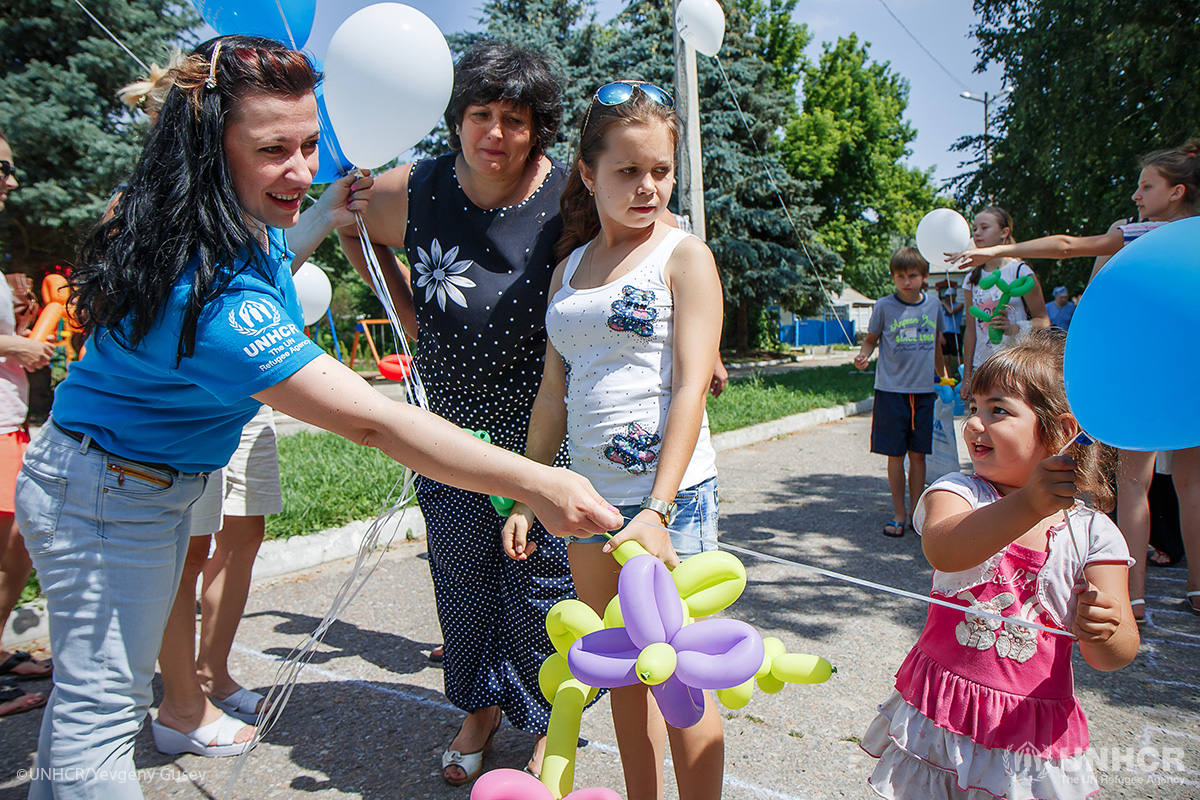 UNHCR Assistant Protection Officer Oleksandra Litvinenko hands out balloons to young children at the World Refugee Day event Our Community Welcomes Friends, at Kreminna community centre in conflict-affected eastern Ukraine.