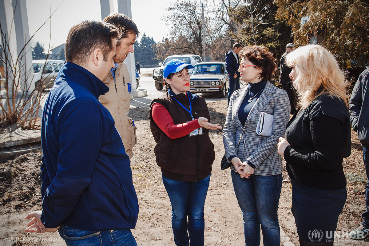 UNHCR Assistant Protection Officer Oleksandra Litvinenko (centre) talks to Mathias Eick (second left), Global Information Officer of the European Civil Protection and Humanitarian Aid Operations (ECHO), and UNHCR Field Office staff, during a visit to a distribution site in Kreminna in conflict-affected eastern Ukraine.