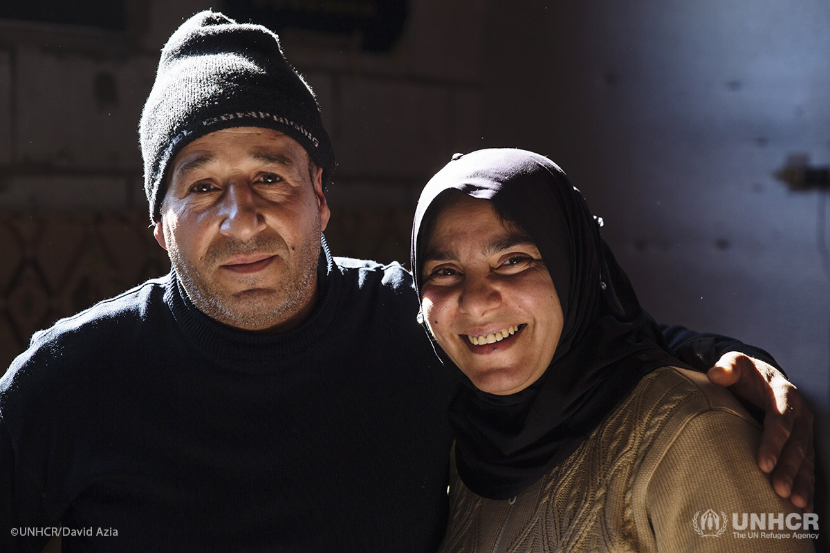 Khaled, 45, a Palestinian refugee displaced from Syria, and his wife Samira, 38, a Syrian refugee, sit on the floor of the apartment they share with their family.