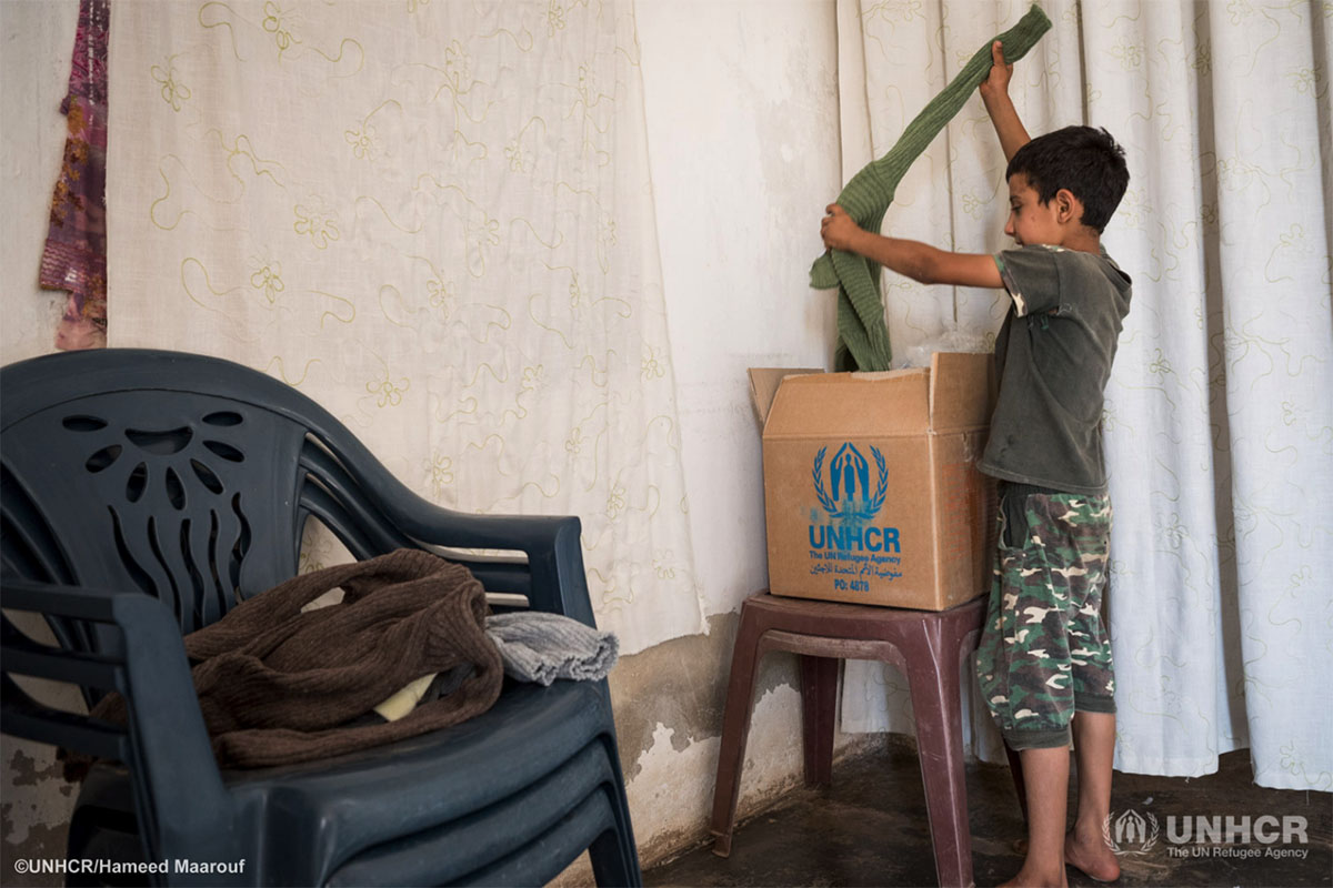 Moayyed opens up his family's UNHCR winter clothing kit.