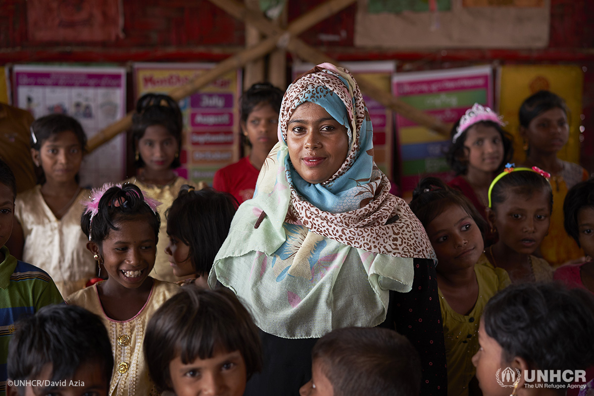 Teacher Taslima Akhtar, 28, poses for a photograph alongside the Rohingya students she teaches at the Protivar Bikash 1 learning center in Kutupalong.