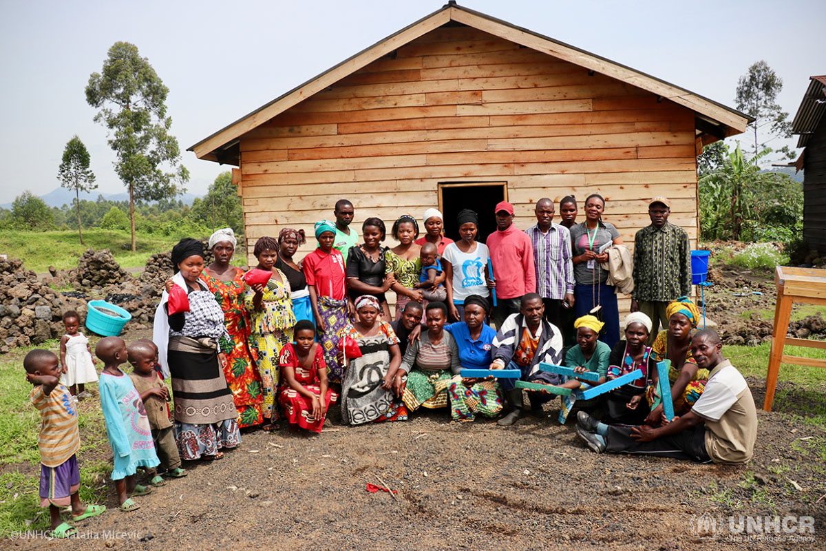 Internally displaced people and members of the local community selected for the project pose in front of the soap and sanitary pad factory built by UNHCR in Kitchanga.