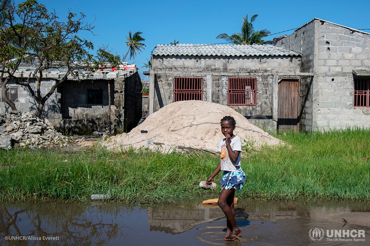 A young girl walks barefoot through floodwater in Beira, Mozambique.