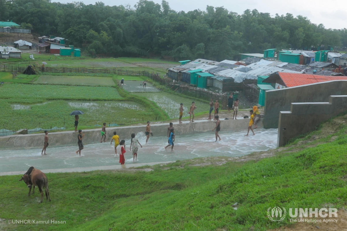 Rohingya children playing in water during monsoon climate emergency