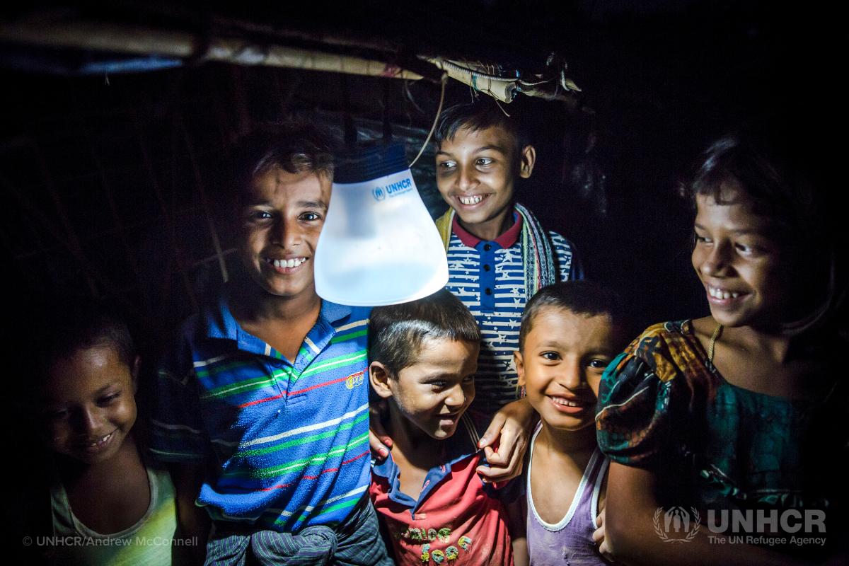 Rohingya children gather around solar lantern