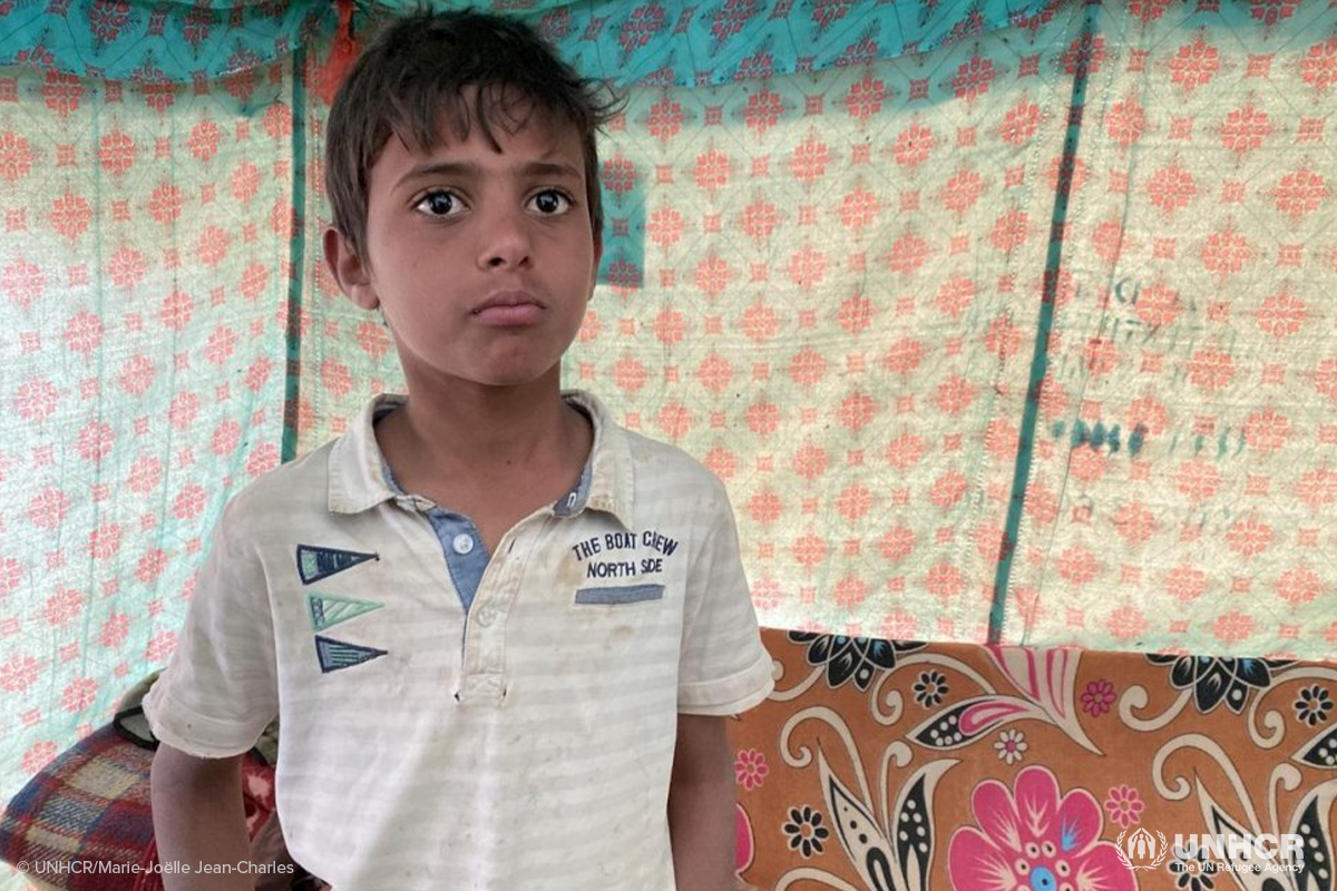 A twelve year old displaced Yemeni boy stands inside the tent he shares with his family