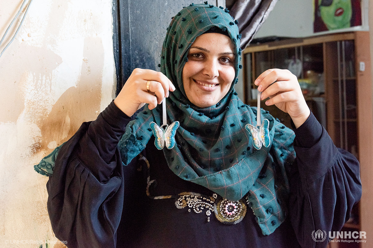 syrian refugee Hiba holds up ornaments she made with made51