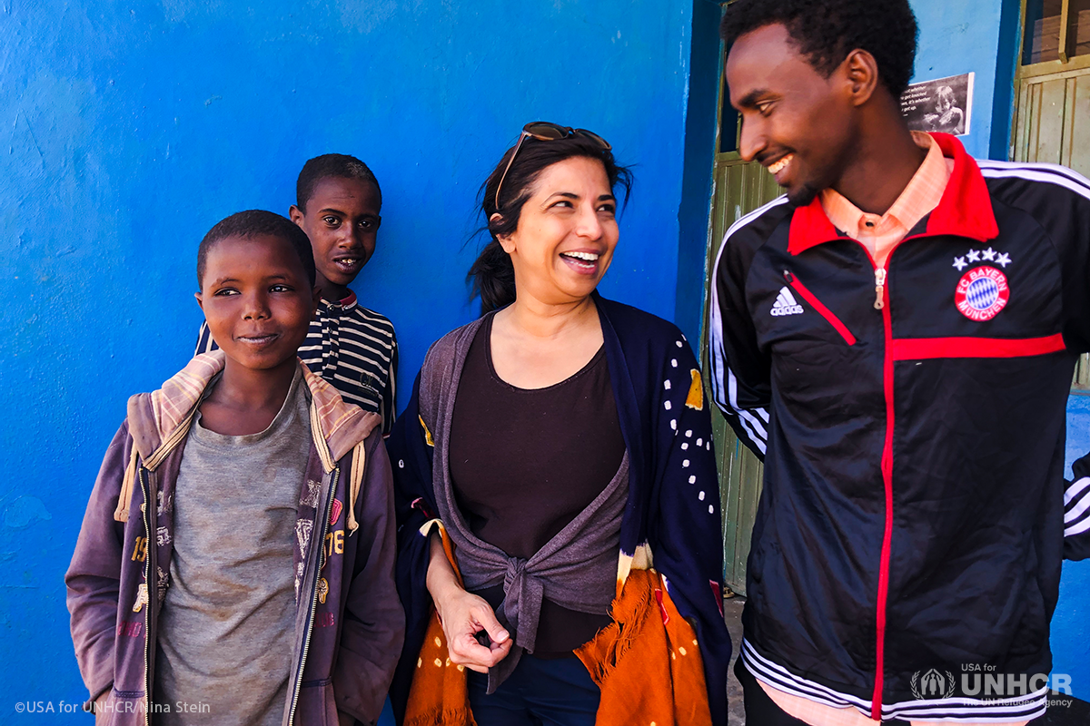 Yasmin smiling with refugees