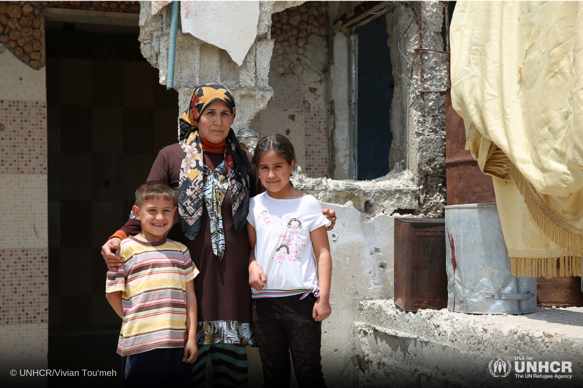 Kholoud stands with her daughter Gardinyah, 10-years-old, and her son Malek 7-years-old in front of their damaged home in Al Hosn village in the western countryside of Homs.