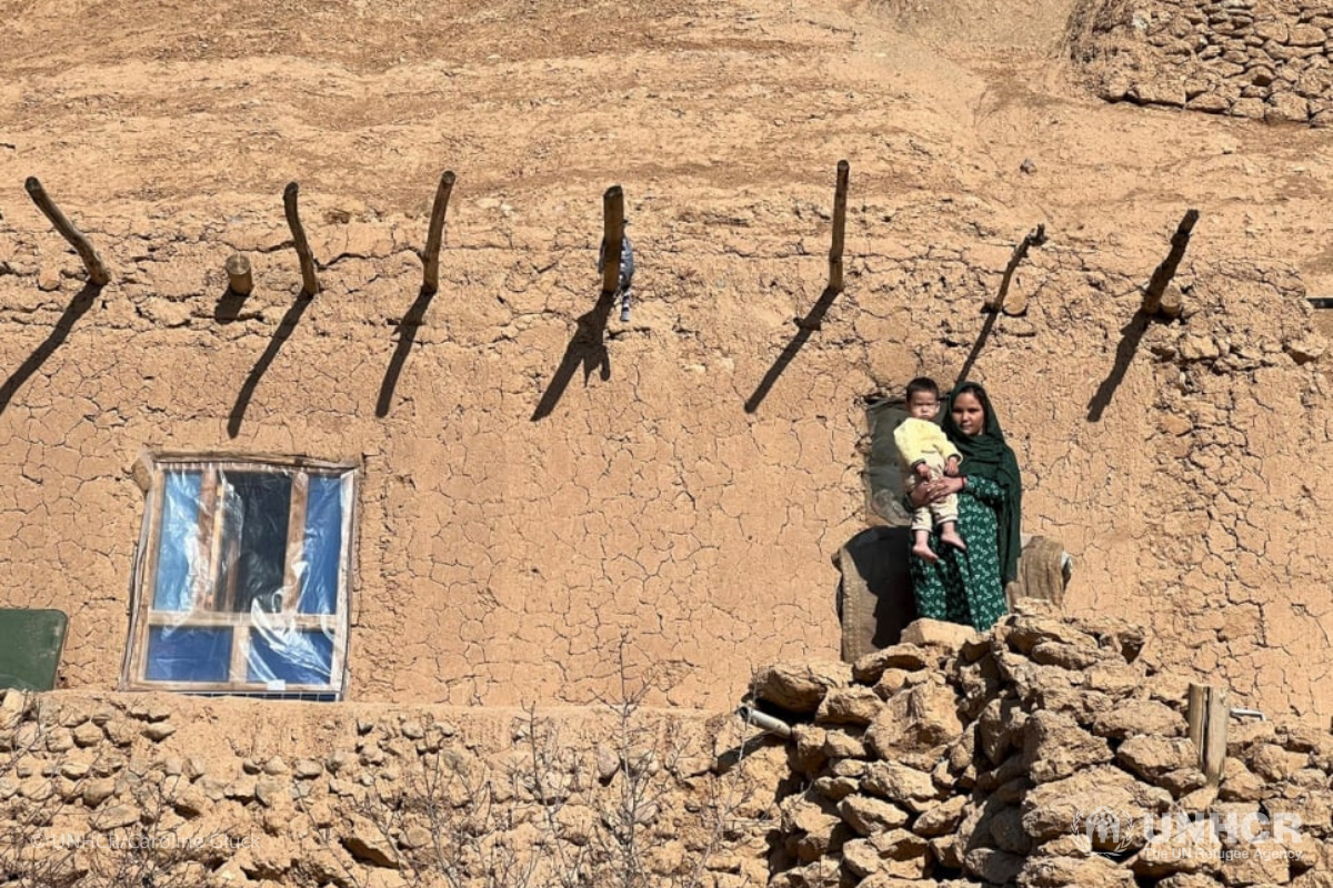 A woman and child stand outside their home in Bamyan Province. Bamyan province is the highest region in Afghanistan, and one of the coldest. But many families are struggling to afford food or fuel to heat their homes.