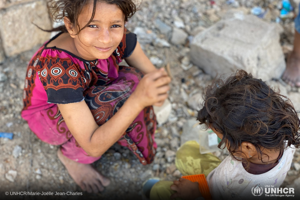 9-year-old internally displaced girl, Ipteehal, plays kitchen with her younger sister Radia outside the unfinished building where they live with other displaced families in Al Mukalla, Hadramaut, Yemen