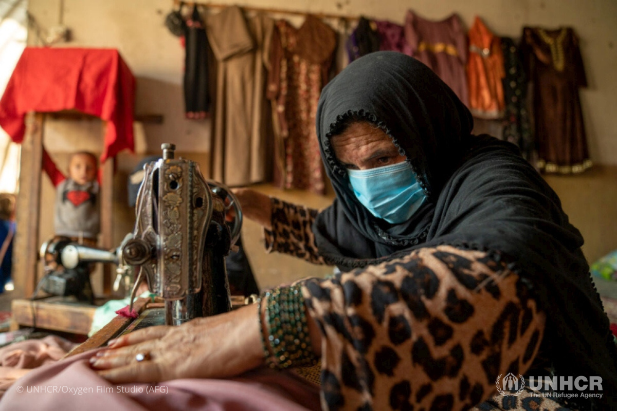 An internally displaced woman living in Jalalabad city in Nangarhar Province works on a garment she is sewing for a customer. She established a tailoring service from her home with support from a UNHCR livelihoods project.