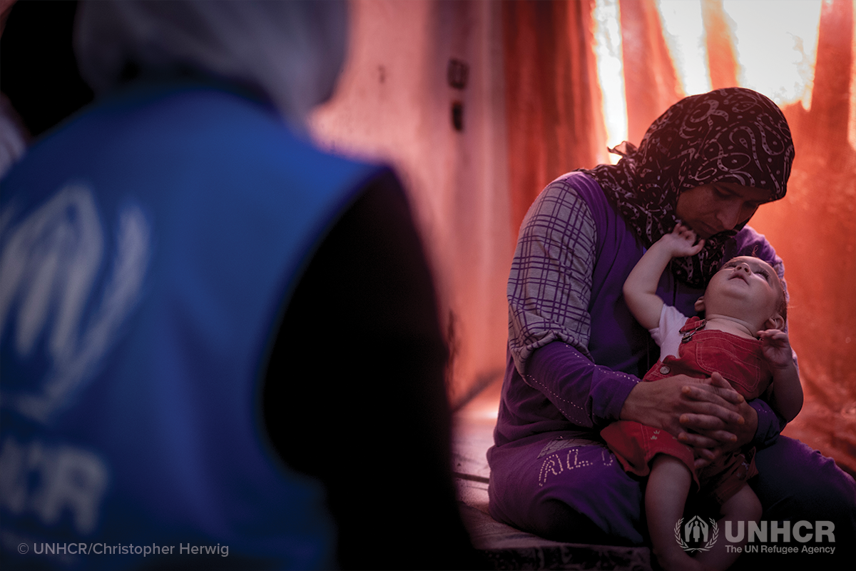 syrian refugee mother holds her child