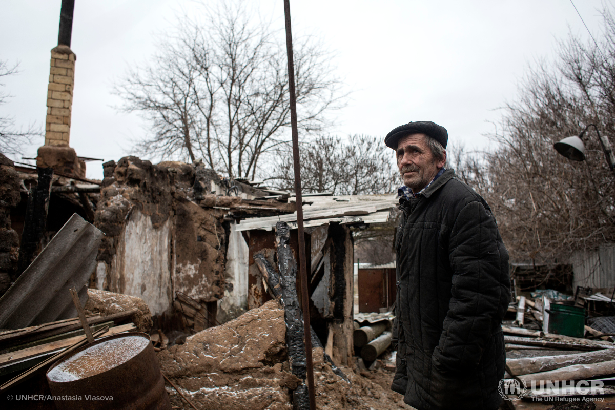 man outside destroyed home in Ukraine in winter