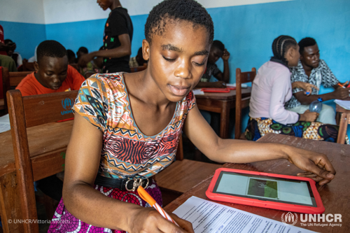 Doriane uses a red tablet to study in her class at the Saint Laurent High School in Zongo.