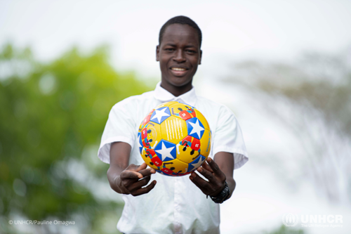 John Sabit Ali, an 18-year-old South Sudanese refugee, holds the football he designed. His drawing was chosen as a winner in the Vodafone Foundation and UNHCR INS football design contest.
