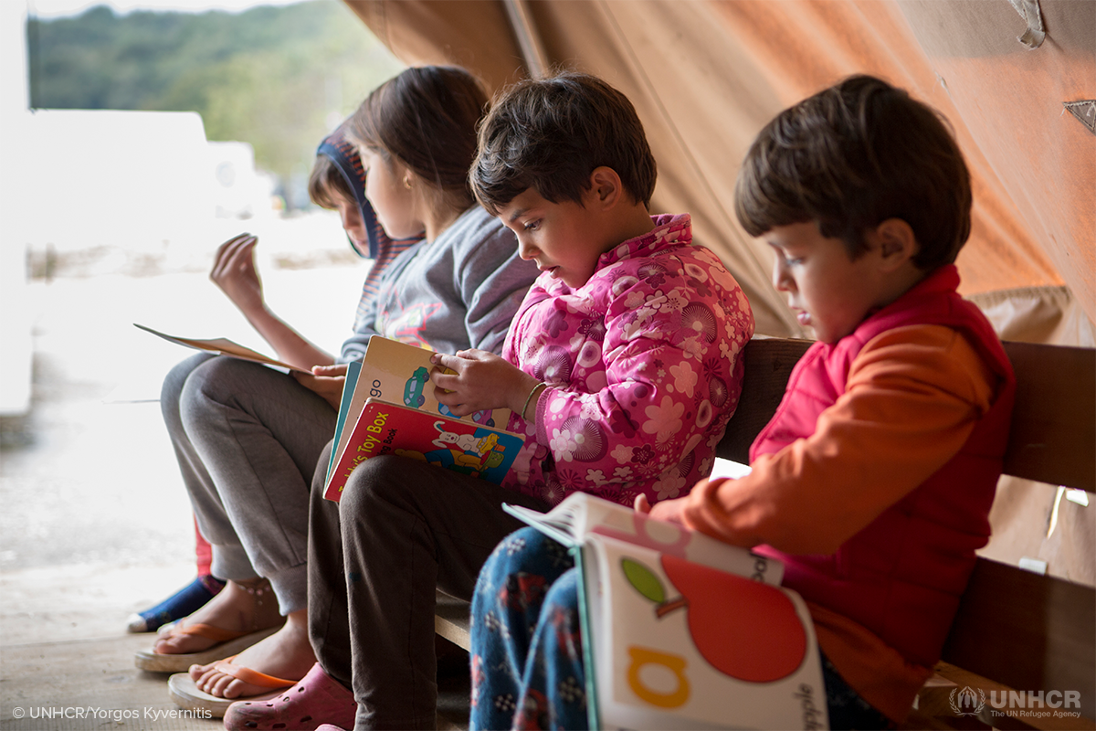 refugee children reading books from library