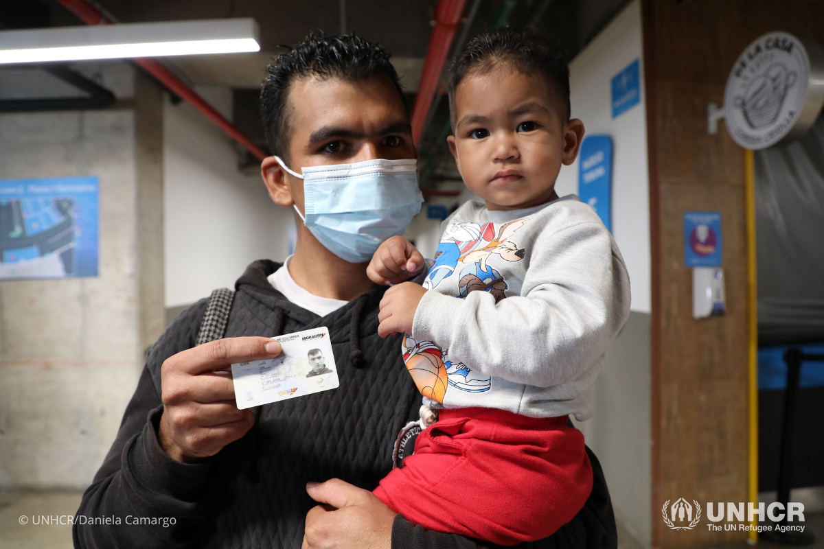 Raúl from Venezuela receives the Temporary Protection Permit for his toddler Tahiner in Bogotá.