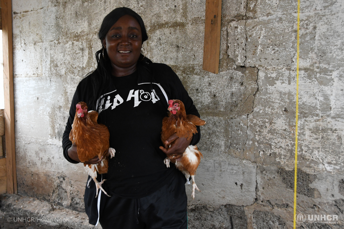 Cameroonian IDP holding two hens