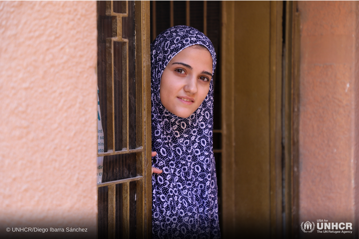 Syrian refugee Alaa stands in the doorway of the house where she lives with her parents in Amman, Jordan.