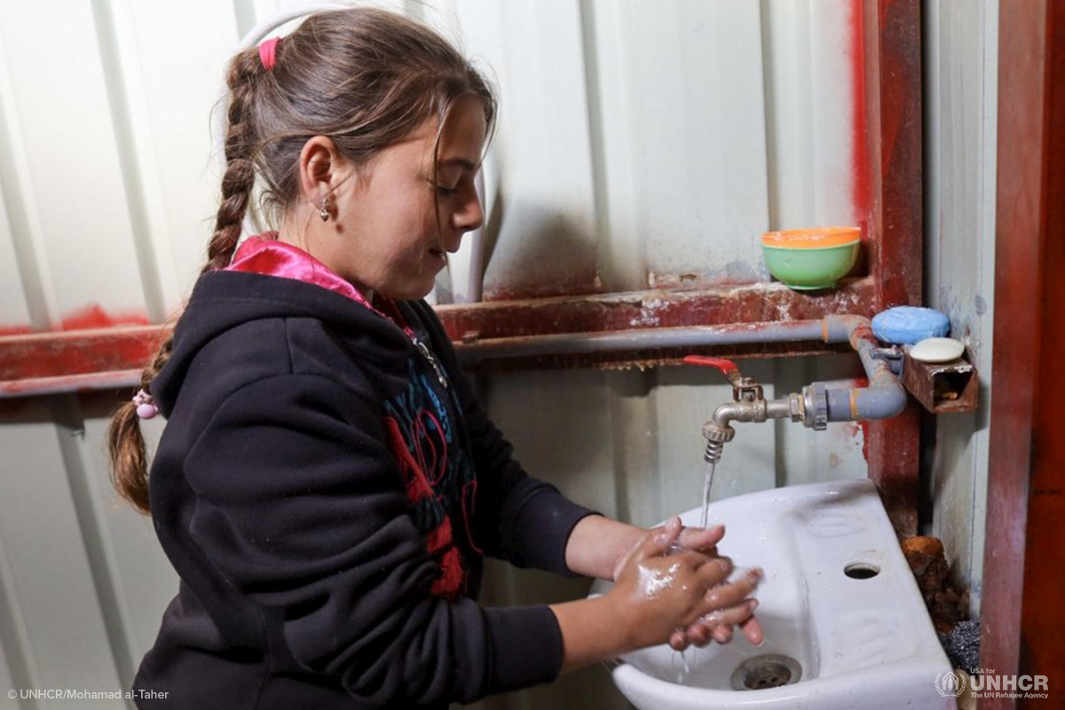syrian girl washes her hands at za'atari refugee camp