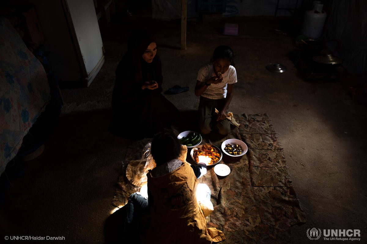 Majida prepares a meal for her children after they return home from school