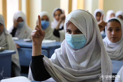 A student raises her hand in class at the girls’ high school built with UNHCR support in the Saracha area of the eastern Afghan city of Jalalabad. 