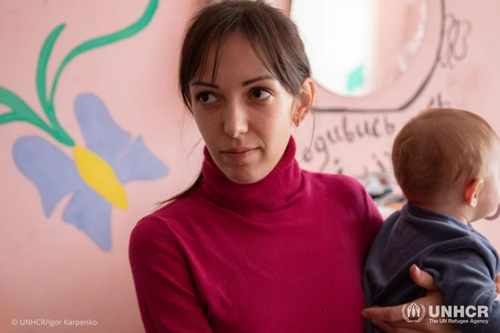 Oleksandra holds 7-month-old daughter Polina in their room at the Mukachevo State University dormitory.