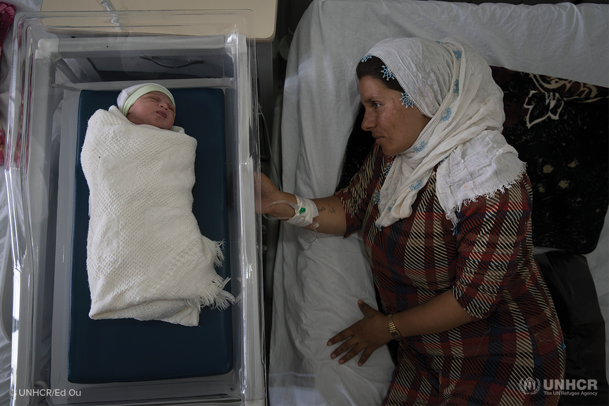 displaced syrian woman lays next to her newborn child