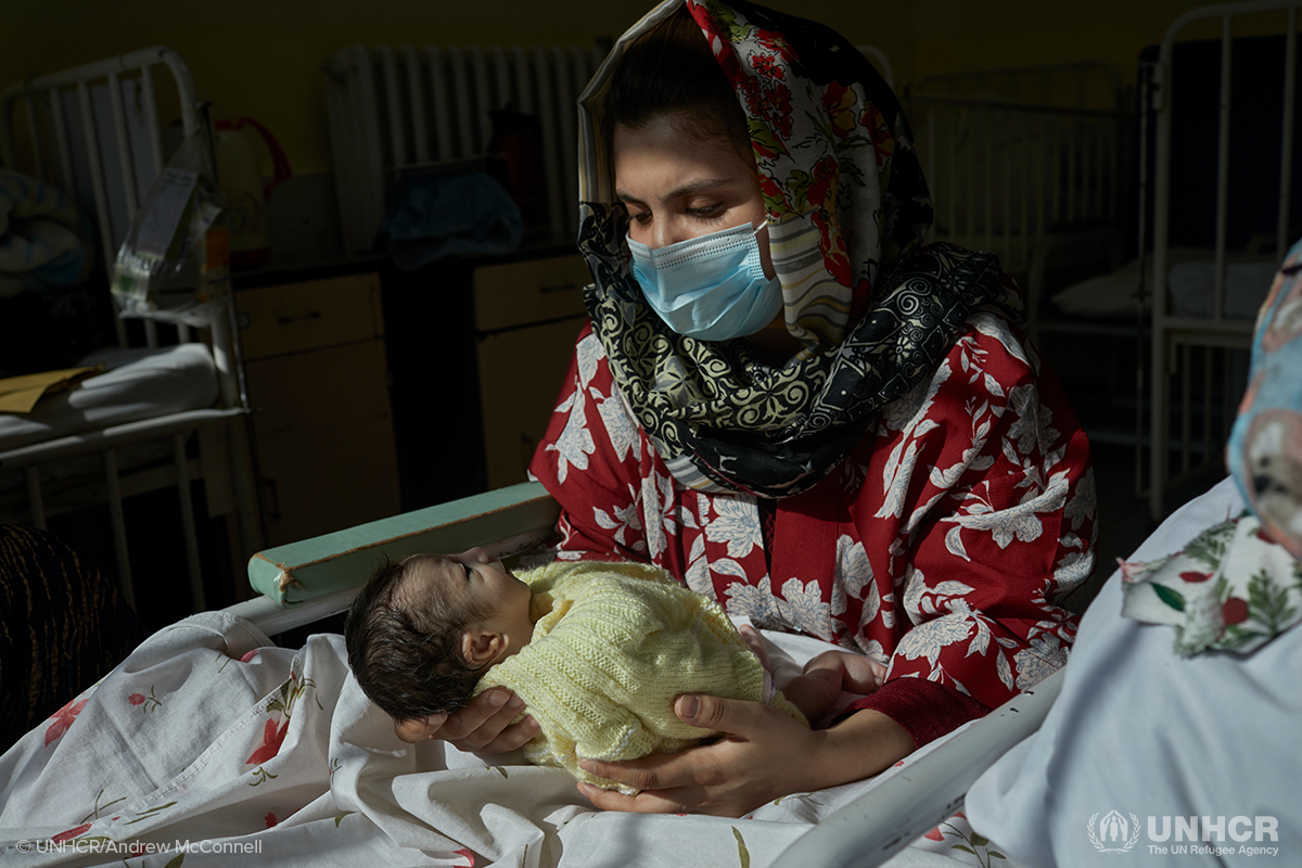 Afghan woman holds her infant child in the hospital