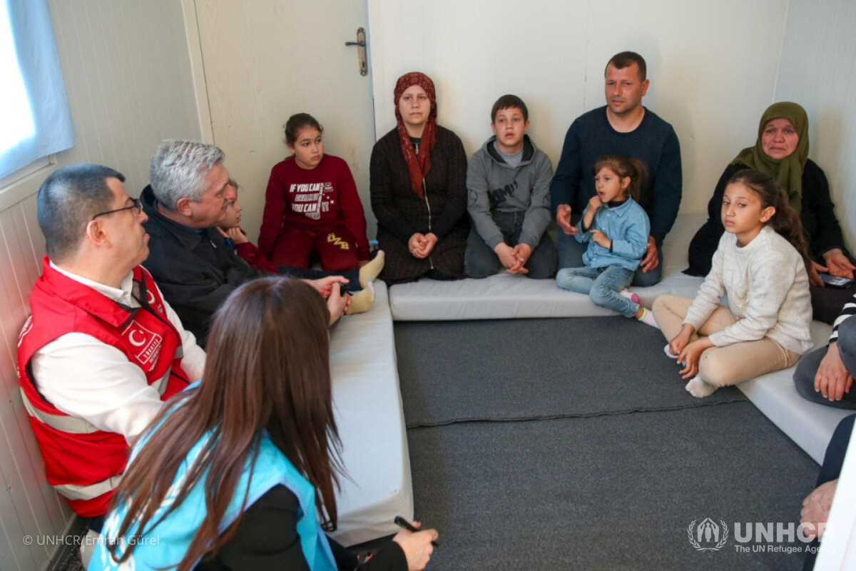 UN High Commissioner for Refugees Filippo Grandi (second from left) meets earthquake survivor Ahmet Erkan and his family at Boynuyoğun Temporary Accommodation Center (TAC) in Hatay, Türkiye. 